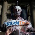 View of a vandalized statue with a banner reading "Dignified education" during protests against the Chilean government on October 29, 2019