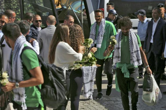 Palestinian women welcome Saudi Arabia's national football team with flowers