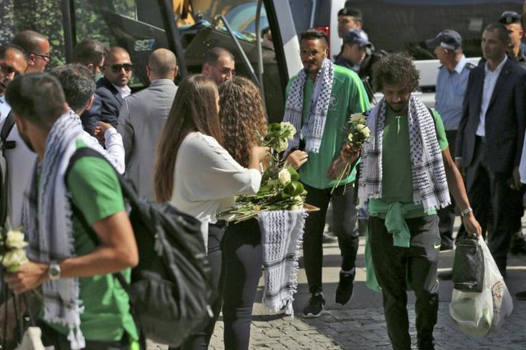 Palestinian women welcome Saudi Arabia's national football team with flowers