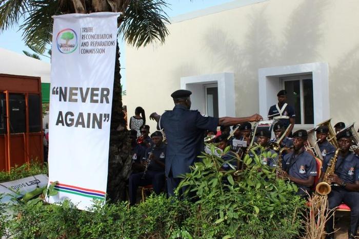 This picture shows a banner reading "Never Again" is seen as a police band performs during the Truth and Reconciliation and Reparation Commission, at the Dune's Resort, in Kotu, near Bajul, on October 15, 2018