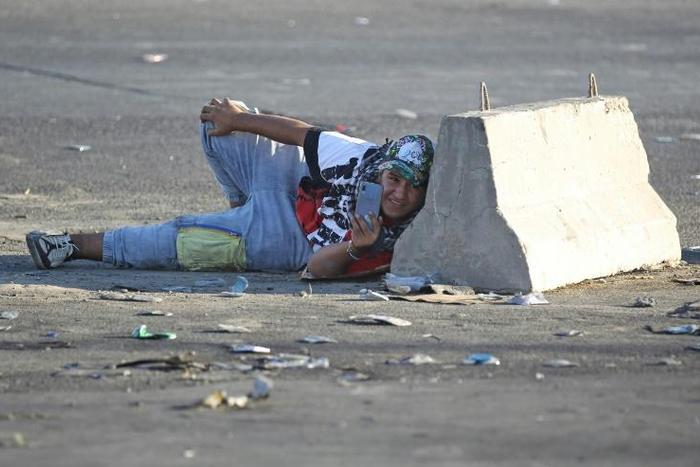 Protesters have used mobile phones to film against a backdrop of tear gas volleys and live rounds during demonstrations that have gripped Iraq since Tuesday