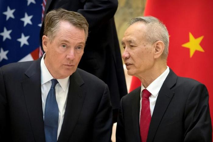 In this file photo taken on February 15, 2019, US Trade Representative Robert Lighthizer (L) listens as Chinese Vice Premier Liu He talks while they line up for a group photo at the Diaoyutai State Guesthouse in Beijing