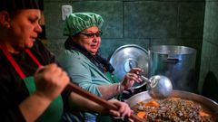 Women serve food at a soup kitchen which feeds at least 200 people hit hard by the economic crisis