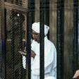 Sudan's ex-president Omar al-Bashir (C) appears in court in the capital Khartoum to face charges of illegal acquisition and use of foreign funds