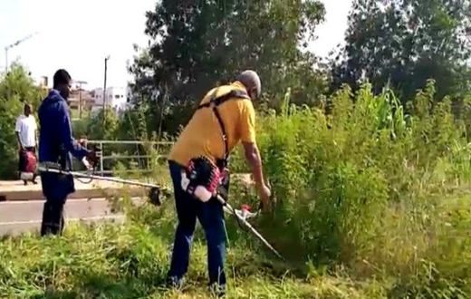 Mahama clears weeds in front of new Military Cemetary