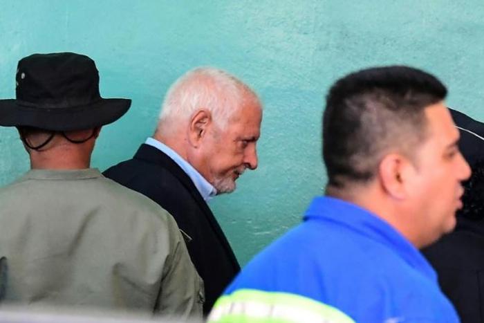 Panama's former president (2009-2014) Ricardo Martinelli (C), is escorted by police officers as he leaves the court where he was attending a hearing over wiretapping allegations