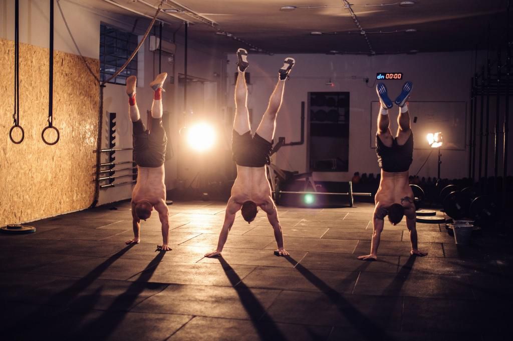 Men walking on hands in gym