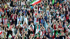 Wearing sporty hats and the national flag, Iranian women cheer for their team at a game they will never forget.