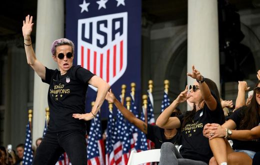 US women's soccer star Megan Rapinoe, left, and her teammates won a court ruling Friday in their fight for equal pay from the US Soccer Federation