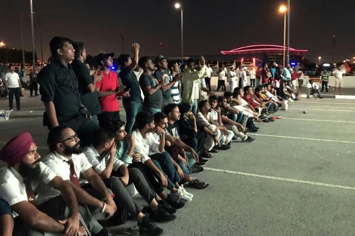 Indian fans who could not get tickets watch on a giant screen outside the stadium where Qatar play India in a World Cup tie