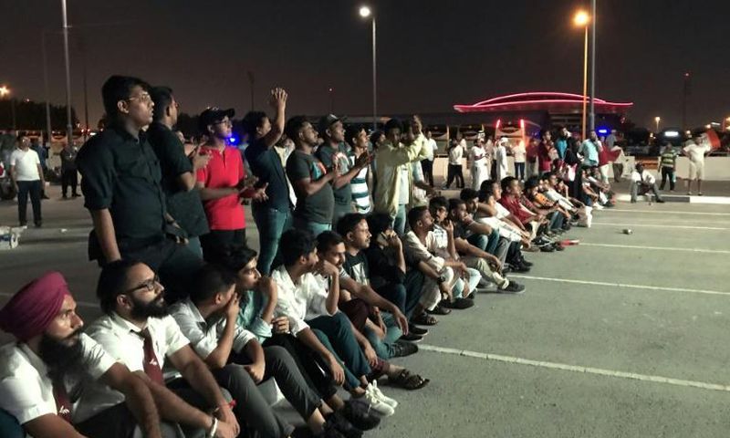 Indian fans who could not get tickets watch on a giant screen outside the stadium where Qatar play India in a World Cup tie