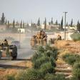 Turkish troops drive their armoured personnel carriers through the village of Qirata on the outskirts of the northern city of Manbij near the Turkish border, on October 14, 2019