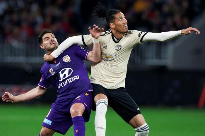 Manchester United's Chris Smalling (R) fights for the ball with Perth Glory's Bruno Fornaroli (L) during a pre-season friendly in Perth on July 13, 2019.