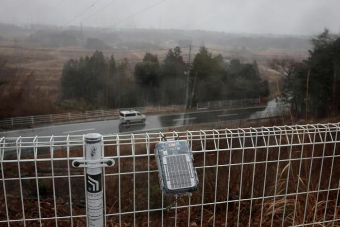 A geiger counter attached to a fence near the Daiichi power plant measures radiation in Okuma town, Fukushima prefecture