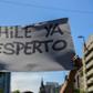 A demonstrator in Santiago holds a sign reading "Chile has awakened"