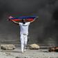 A demonstrator waves a Haitian flag during a protest against President Jovenel Moise on October 4, 2019 in Port-au-Prince