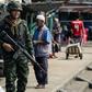 A Thai soldier patrols the Tak Bai riverside market on Friday's anniversary