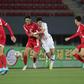 South Korea's Hwang Ui-jo and North Korea's Ri Yong Jik fight for the ball during the World Cup 2022 Qualifying match in Pyongyang