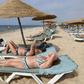 Tourists sunbathe on a private beach near a hotel in Tunisia's Nabeul on July 1, 2018