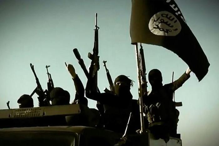 In this file image grab taken from a 2014 propaganda video purports to show Islamic State fighters raising their weapons