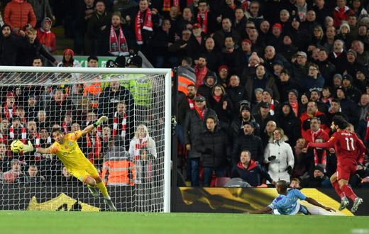 A Mohamed Salah (R) header beats Manchester City goalkeeper Claudio Bravo to give Liverpool a two-goal lead in an English Premier League clash at Anfield