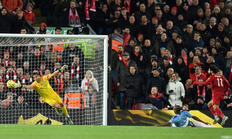 A Mohamed Salah (R) header beats Manchester City goalkeeper Claudio Bravo to give Liverpool a two-goal lead in an English Premier League clash at Anfield