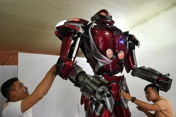 Made from recycled motorbike parts, 'Robot One' has an environmental message, says engineer Do Danh Phong (L)