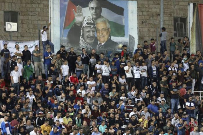Spectators watch a match between Palestinian team Hilal al-Quds and Morocco's Raja Casablanca -- the first Moroccan football team to play in the occupied Palestinian territories on October 3, 2019