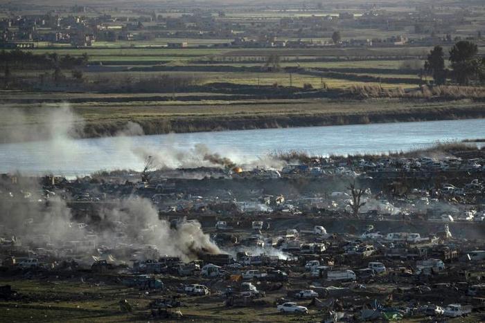 Smoke rises above the remains of the makeshift encampment on the north bank of the Euphrates River that had been the centre of the Islamic State group's last stand before it was overrun by the US-backed Syrian Democratic Forces earlier this week