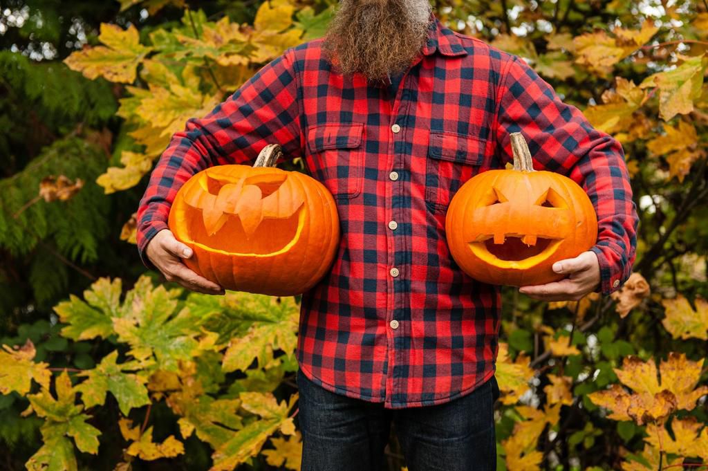 Mature man holding carved pumpkins