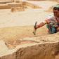 A woman cleans a burial site belonging to the Indus Valley Civilization during an archeological excavation in Baghpat, India in 2018; scientists have sequenced the genome of an individual from the ancient civilization for the first time
