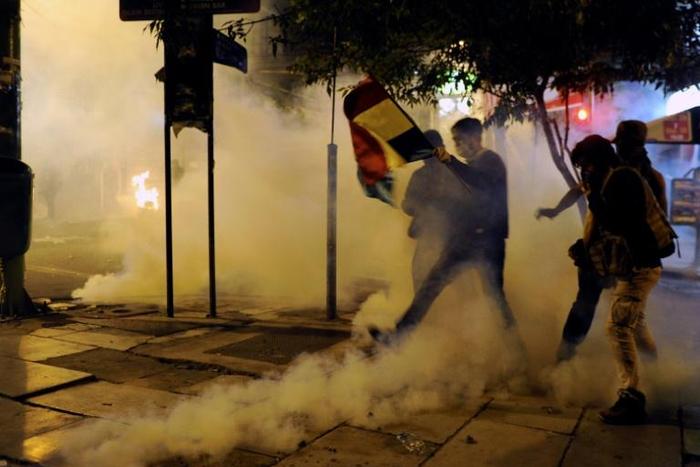 Supporters of Bolivia's presidential candidate Carlos Mesa are dispersed with tear gas by riot police during a protest in front of the Electoral Supreme Court