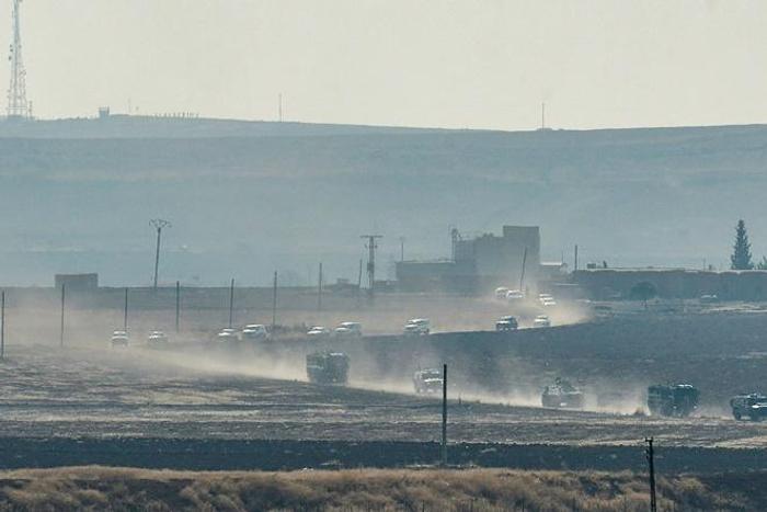A convoy of Russian and Turkish military vehicles snakes its way along the Syrian side of border in the first joint patrol of a buffer zone set up under an agreement struck by Ankara and Moscow last week