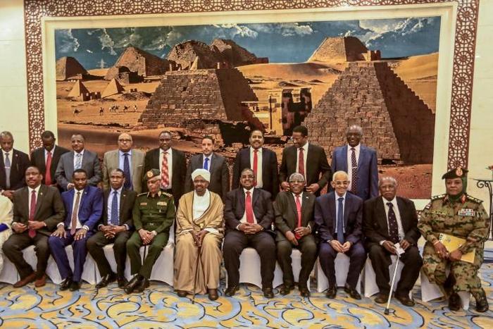 Sudan's President Omar al-Bashir (6th-L, front) poses for a group photo with members of his new 20-member cabinet as they take the oath of office at the presidential palace in Khartoum