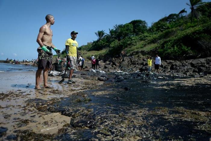 The oil has been seen along Brazil's northeastern Atlantic coast, including Pernambuco state, where volunteers are pictured cleaning up on October 21, 2019