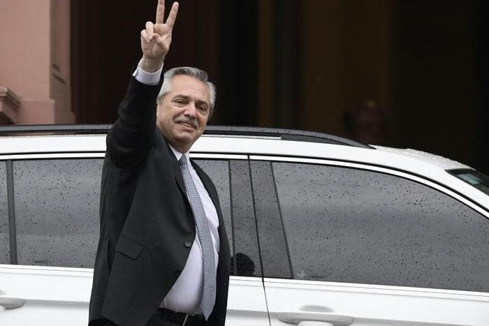 Argentina's president-elect Alberto Fernandez flashes de "V" sign as he leaves the Casa Rosada presidential palace after a meeting with President Mauricio Macri
