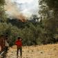 Refugees and migrants look at a fire that broke out in the camp of Moria in Mytilene on September 29, 2019