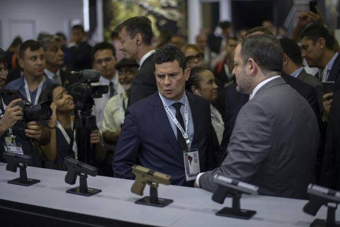 Brazilian Justice Minister Sergio Moro (C) looks at guns during the Latin American Defense and Security exhibition (LAAD 2019) in Rio de Janeiro, Brazil, on April 2, 2019