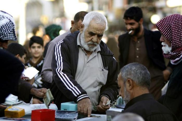 Economy under pressure: Iranian tourists exchange Iranian Rial banknotes in the central Iraqi shrine city of Najaf