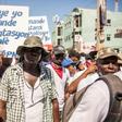Police officers hold a placard with the slogan, "Policemen demand higher wages" during a demonstration by police and their supporters in Port-au-Prince