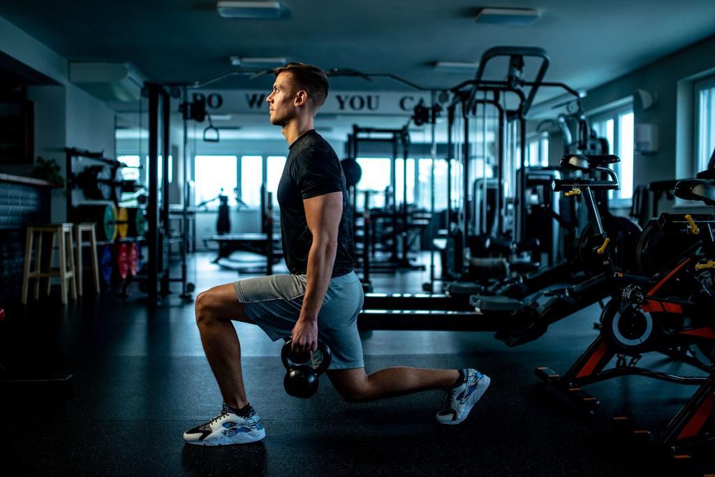 Young man Practicing Walking lunge with Kettle bell