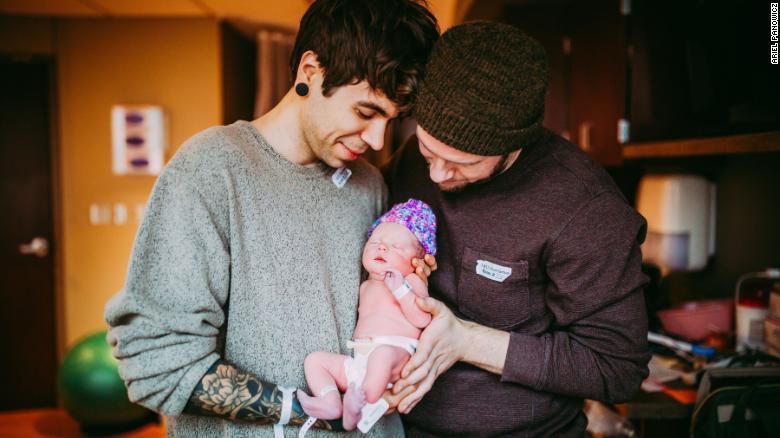 The proud fathers hold their new child (Ariel Panowicz)