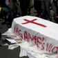 A member of the Rwanda National Congress opposition party puts pictures of slain party founder Patrick Karegeya next to a mock coffin reading "Kagame's victims" during a demonstration outside the Rwandan embassy in Pretoria