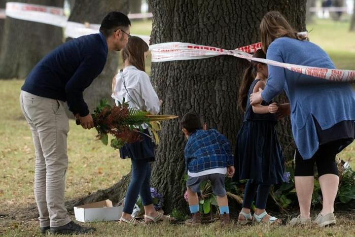 New Zealanders lay flowers near one of the mosques targeted in Friday's deadly attack