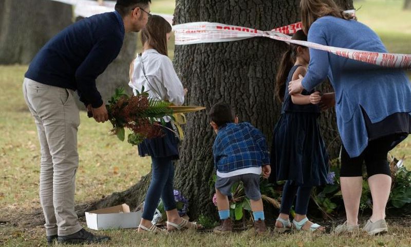 New Zealanders lay flowers near one of the mosques targeted in Friday's deadly attack