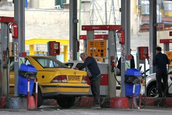 Iranian motorists fill up at a petrol station in the capital Tehran