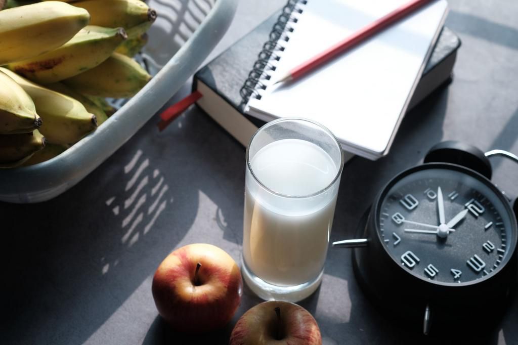 top view of fruit, milk and clock