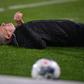 Freiburg head coach Christian Streich lies on the pitch after being barged by Frankfurt captain David Abraham on Sunday.