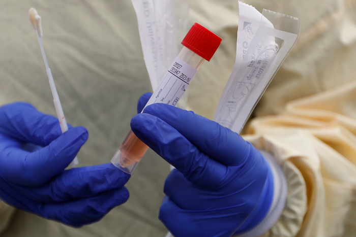 A nurse holds swabs and test tube to test people for COVID-19 at a drive through station set up in the parking lot of the Beaumont Hospital in Royal Oak, Mich., Monday, March 16, 2020. (AP Photo/Paul Sancya)
