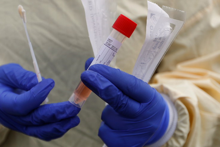 A nurse holds swabs and test tube to test people for COVID-19 at a drive through station set up in the parking lot of the Beaumont Hospital in Royal Oak, Mich., Monday, March 16, 2020. (AP Photo/Paul Sancya)